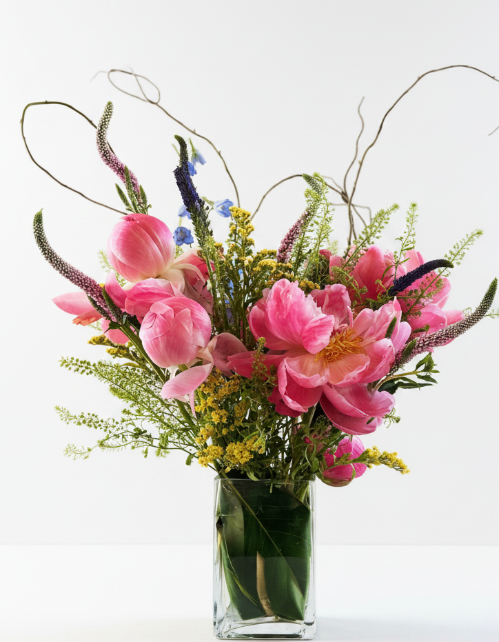 Bouquet of pink flowers in a clear vase on a white background