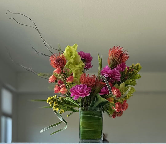 Bouquet of flowers in a clear vase on a neutral background