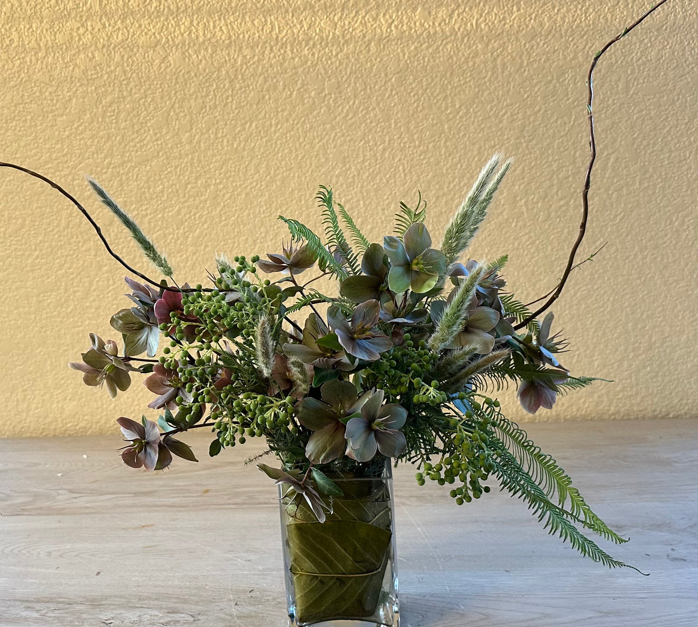 Hellebores roses in leaf-wrap vase