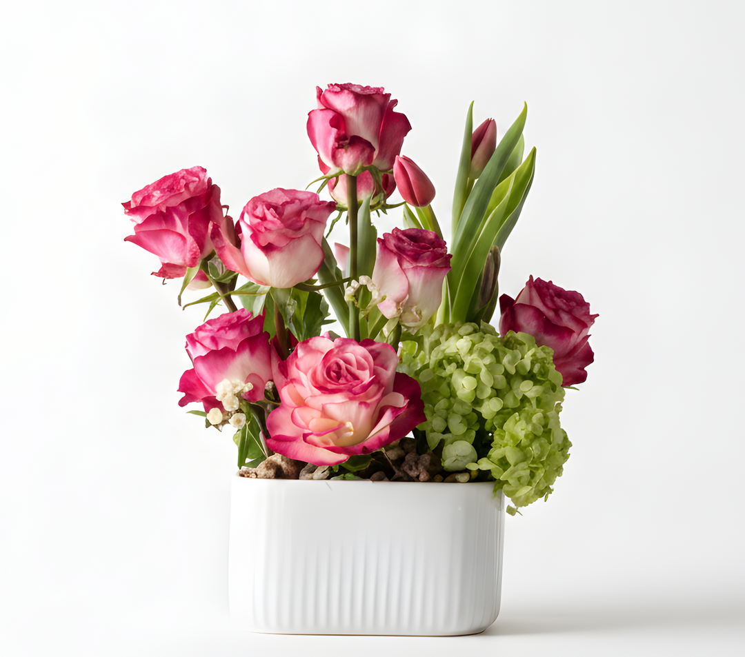 Bouquet of pink flowers in a white vase on a light background