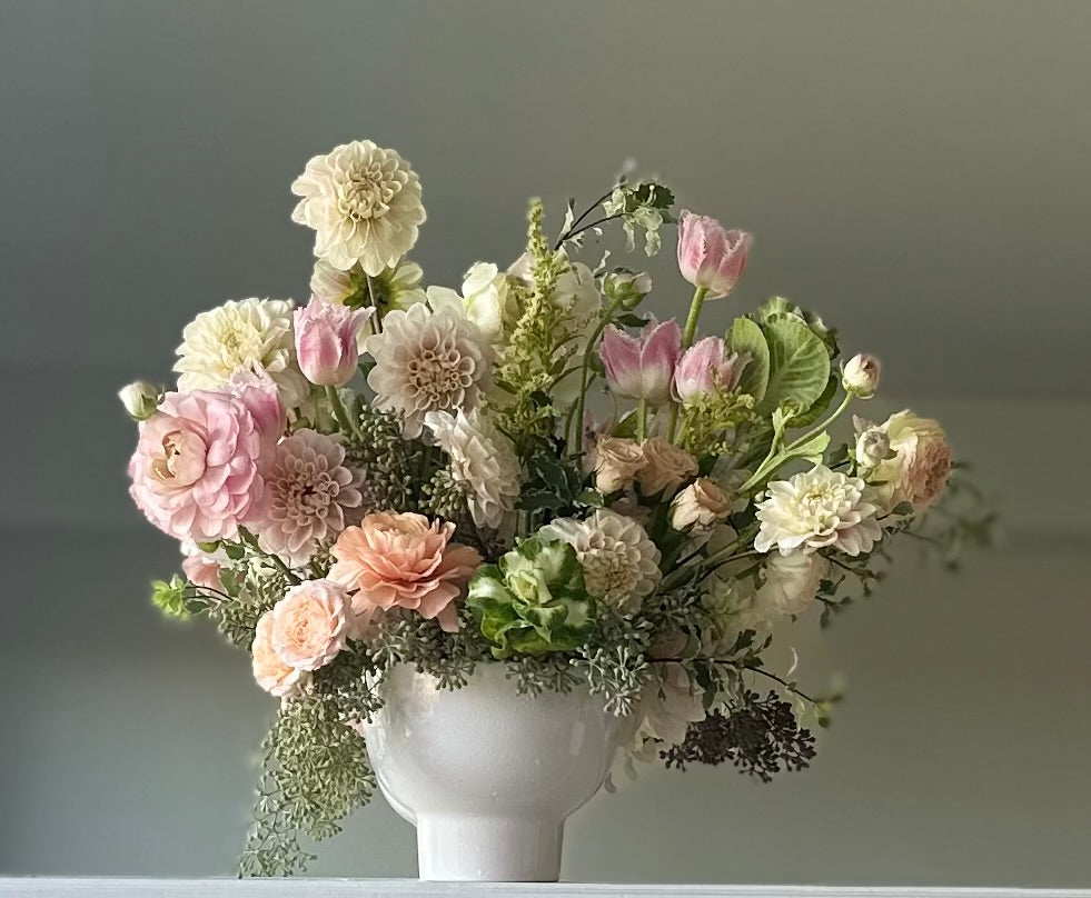 Bouquet of flowers in a white vase against a neutral background